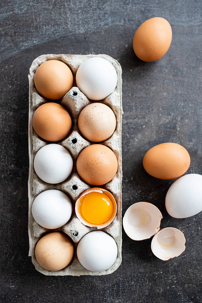 Huevos crudos orgánicos frescos, blancos, beige y marrón, uno está agrietado
 - Foto, imagen
