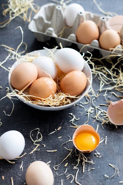 Huevos crudos orgánicos frescos, blancos, beige y marrón, uno está agrietado
 - Foto, Imagen