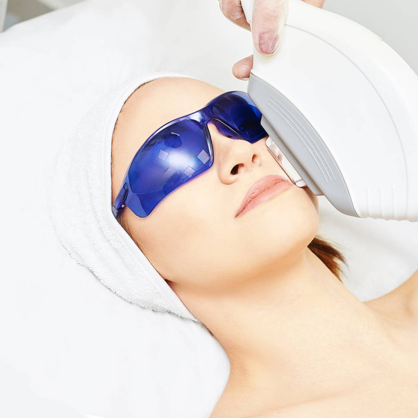 Laser facial hair removal. Cosmetology ipl device. Woman body in clinic. Medical beauty girl. Acne salon treatment tool - Valokuva, kuva
