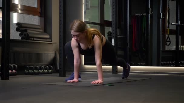Young and tired motivated sportsgirl doing lunges being concentrated in gym. - Filmagem, Vídeo