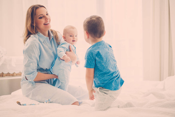 Šťastný střední věku matky se svými dětmi v posteli - Fotografie, Obrázek