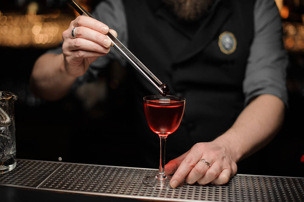 CLoseup of bartender putting cherry in an alcohol drink - Foto, immagini