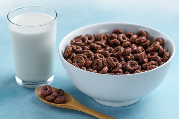 Spoon and bowl with chocolate rings and a glass of milk for dry, cereals breakfast - Foto, immagini