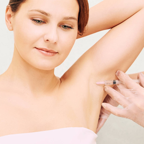 Armpit cosmetology injection. Sweat treatment in cosmetic clinic. Woman skin care procedure. Doctor hand - Foto, afbeelding