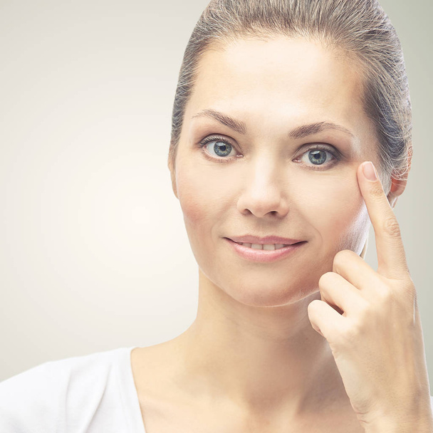 Woman point at dermatology skin problem. Cosmetology beauty girl portrait. Face care procedure - Foto, Bild