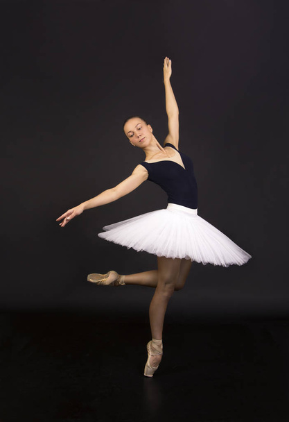 Gorgeous ballerina in a white tutu dancing ballet. Studio shooting on a dark background , isolated images. - 写真・画像