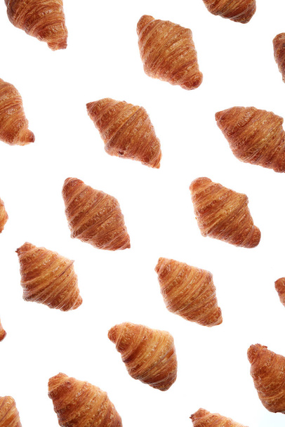 Food pattern with freshly baked homemade delicious croissants on a white background. - Фото, зображення