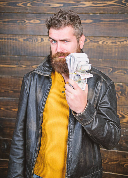 Brutal man has cash money. Richness and wellbeing. Man brutal bearded hipster wear leather jacket and hold cash money. Mafia business. Illegal profit and black cash. Guy mafia dealer with cash profit - Photo, image