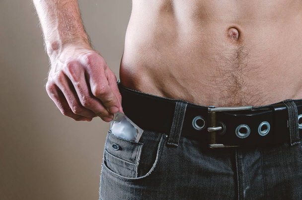 A la cintura un hombre desnudo y atractivo en jeans negros tira de un cond
 - Foto, imagen