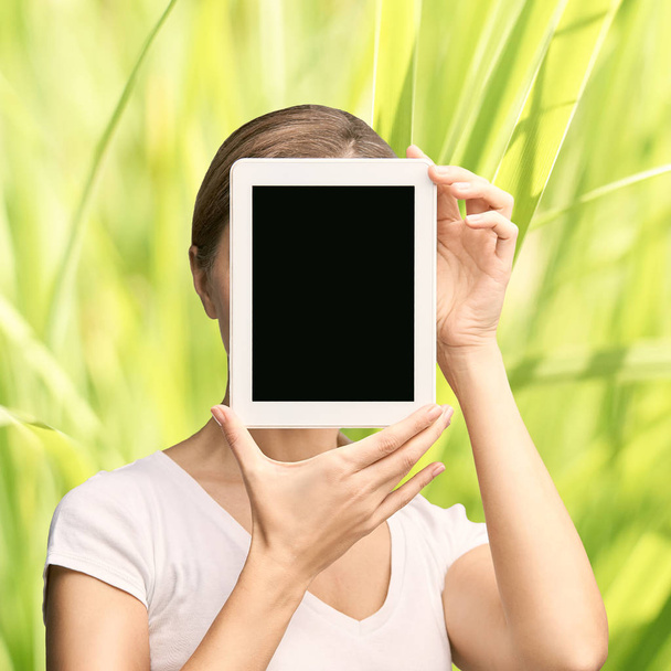 Girl holding computer pad. Mock up at tablet black screen. Face near laptop. Woman showing pc - Фото, зображення