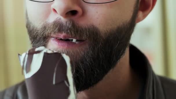 Close-up retrato de homem barbudo faminto comer sorvete de chocolate alegre
 - Filmagem, Vídeo