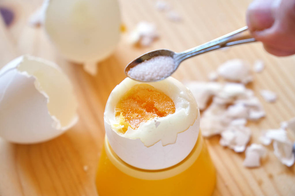 Colocar um sal no ovo de galinha fervido durante o café da manhã
 - Foto, Imagem
