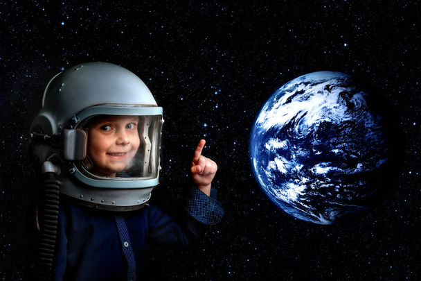 A small child imagines himself to be an astronaut in an astronaut's helmet. - Photo, image