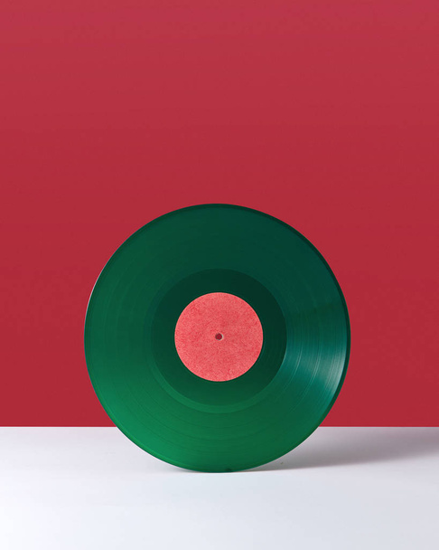 Green music record, on a double white red background with space for text. Retro audio technology - Photo, image