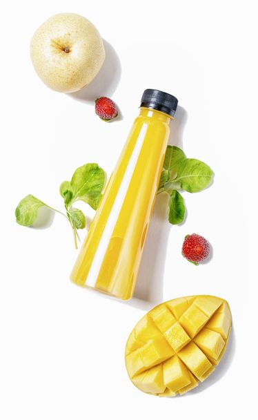 top view flat lay yellow bottle of juice with spinach, strawberries mango and pear isolated on white background. Healthy lifestyle, vegetarian food concept. Detox  - Photo, image