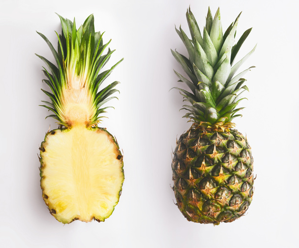 Whole and half pineapple on white - Foto, afbeelding