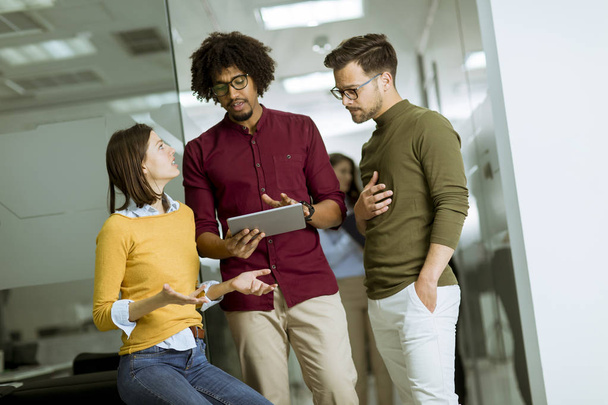 junges multiethnisches Business-Team mit einem digitalen Tablet im Büro eines kleinen Start-up-Unternehmens - Foto, Bild