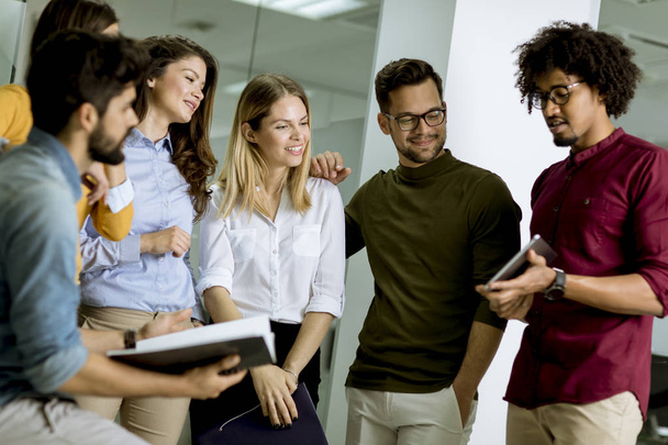 Gruppo multietnico di giovani in piedi in uffici moderni e brainstorming
 - Foto, immagini