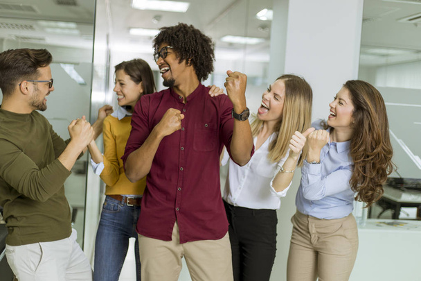 Muotokuva ryhmä nuoria innoissaan liikemiehiä kädet pystyssä virassa
 - Valokuva, kuva