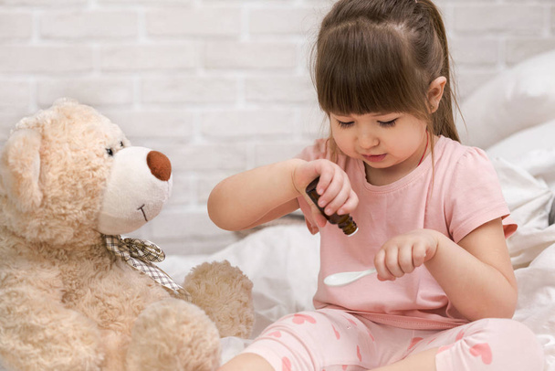 cute child girl playing doctor with teddy bear - Foto, Imagen