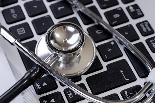 Stethoscope on modern keyboard on doctor desk. Medical science technology concept - Photo, Image