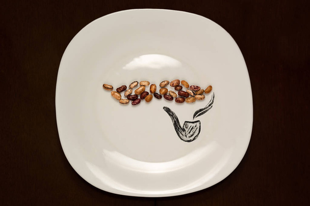 plate with beans in the shape of a mustache and a pipe - Foto, Bild