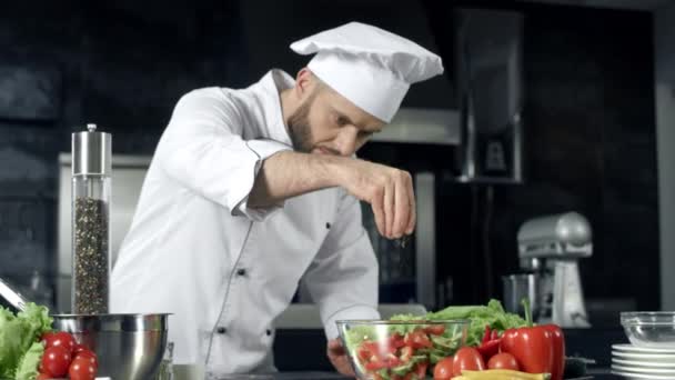 Koch würzt Gemüse in Zeitlupe. Koch kocht frische Lebensmittel in der Küche. - Filmmaterial, Video