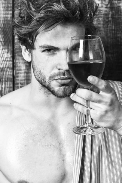 Macho tousled hair degustate luxury wine. Drink wine and relax. Erotic and desire concept. Guy attractive relaxing with alcohol drink. Man sexy chest sweaty skin hold wineglass. Bachelor enjoy wine - Foto, Bild