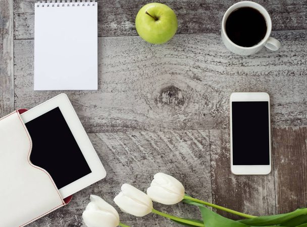 White tablet, phone, cup of coffee, notebook, green apple and fl - Foto, Imagen