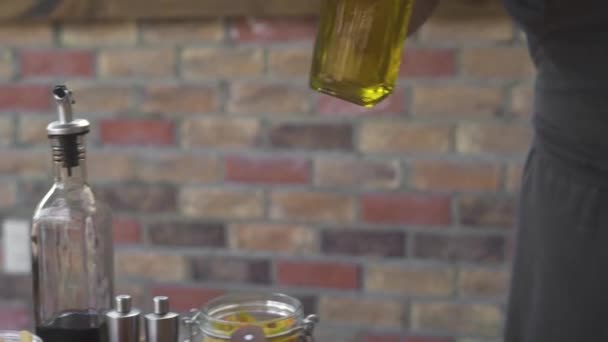 Chef cook pouring olive oil from glass bottle while cooking food on kitchen. Man pouring olive oil while preparing healthy food on restaurant kitchen. - Footage, Video