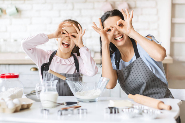 Cute little girl and her mother playing in kitchen - Photo, Image