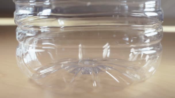 Malé světové globy spadající do plastikové láhve s vodou - Záběry, video