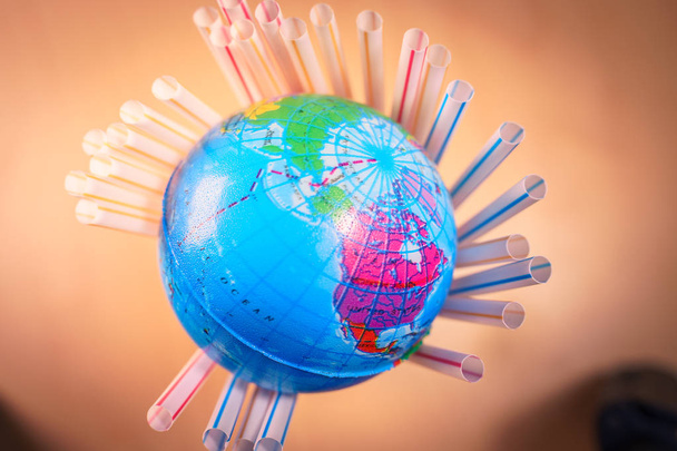 Wereld globes gesteund door plastic rietjes. Ecologie concept. - Foto, afbeelding