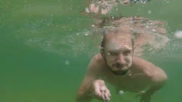 Vista en cámara lenta de la natación y el hombre de buceo en un hermoso lago de montaña. vídeo selfie
 - Imágenes, Vídeo