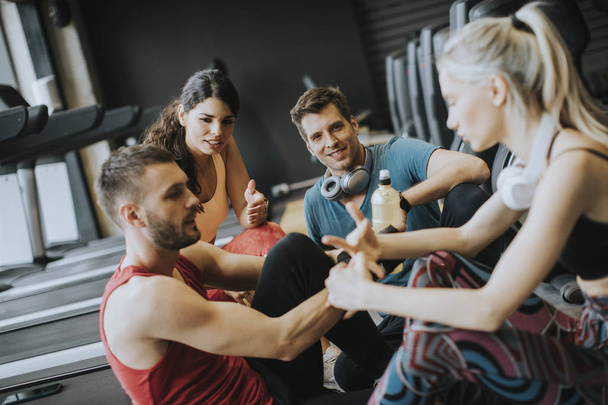 Friends in sportswear talking  together while standing in a gym  - Fotografie, Obrázek