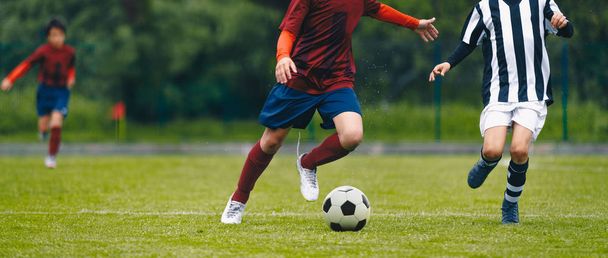 フィールド上のボールを追いかけるサッカー選手 - 写真・画像