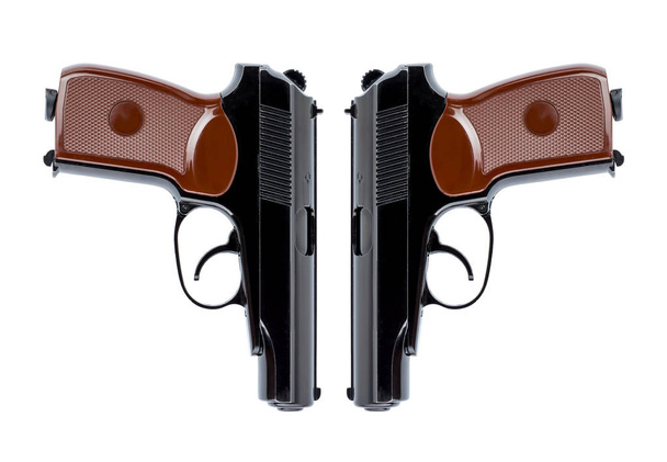 Dos pistolas dirigidas simétricamente por los troncos
 - Foto, imagen