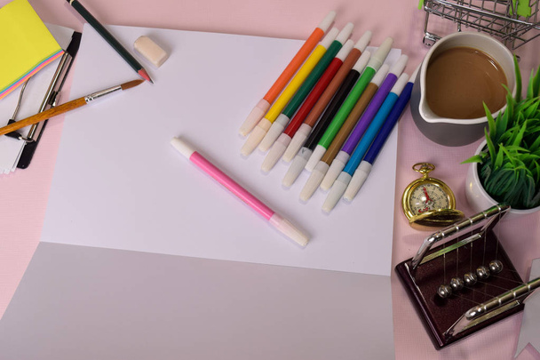 Vista superior del cuaderno abierto con un dibujo marcador en una mesa rosa, preparándose para hacer la tarea. Concepto de escritorio de dibujo
 - Foto, Imagen