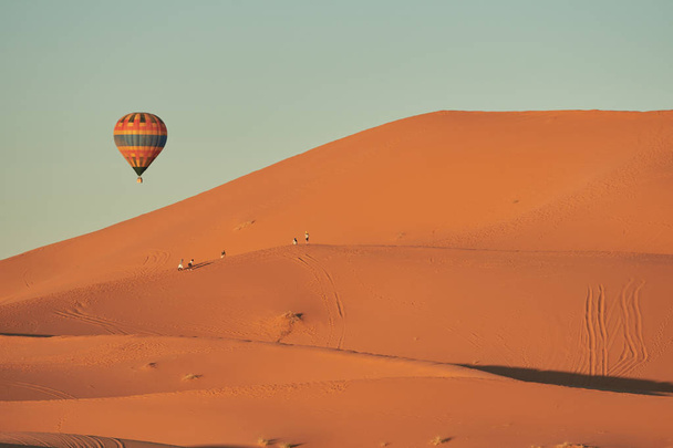 une montgolfière survolant le désert
 - Photo, image