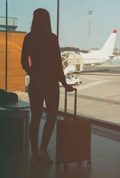 νεαρή γυναίκα με αποσκευές στο αεροδρόμιο. - Φωτογραφία, εικόνα