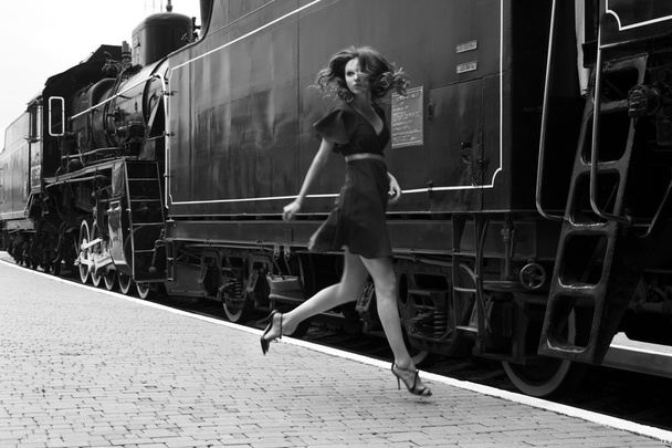 kaunis tyylikäs upea nainen hyppää junassa hymyillen, katsoen
 - Valokuva, kuva