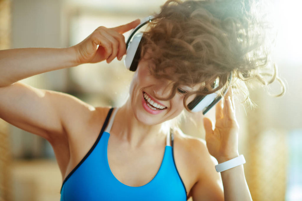 woman listening to music with headphones in modern house - Fotó, kép