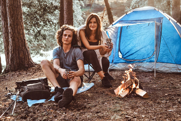 Attractive young couple have a rest in summer forest - 写真・画像