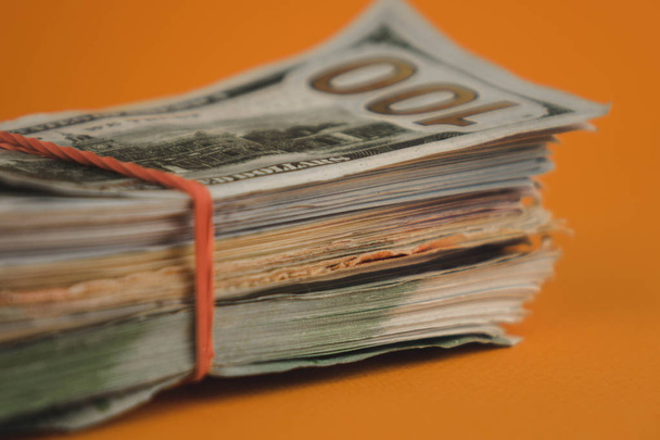 pacote de dólares deitado no fundo laranja fechar
 - Foto, Imagem