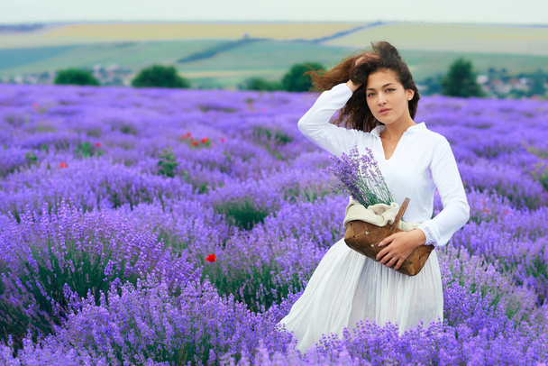 giovane donna è nel campo di fiori di lavanda, bellissimo paesaggio estivo
 - Foto, immagini