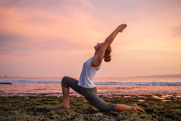 Caucasian woman practicing yoga at seashore - Zdjęcie, obraz