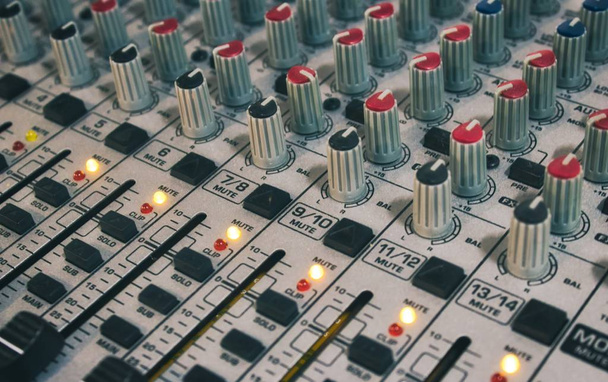 Close-up de mesa de mistura de áudio com botões e controles deslizantes
 - Foto, Imagem