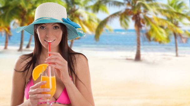 Woman holding a fruit cocktail on a tropical beach - Foto, Bild