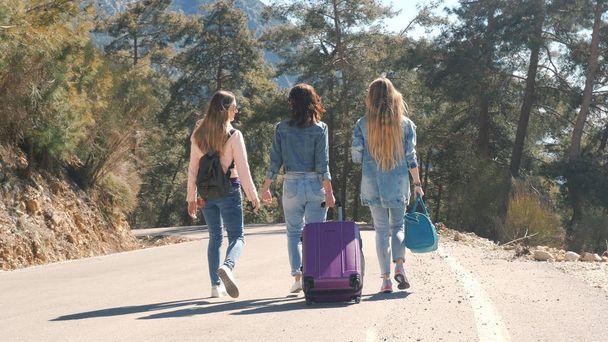 Three young girls walking down the road with beautiful nature landscape - Valokuva, kuva