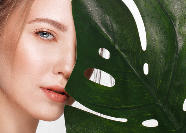 Beautiful fresh girl with perfect skin, natural make up and green leaves. Beauty face. - Фото, зображення